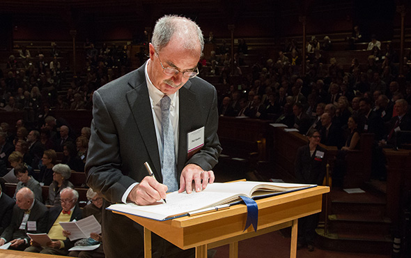 President Phil Hanlon ’77 signs the American Academy of Arts and Sciences’ book of members, a tradition that dates back to 1780. (Photo courtesy of the American Academy of Arts and Sciences)